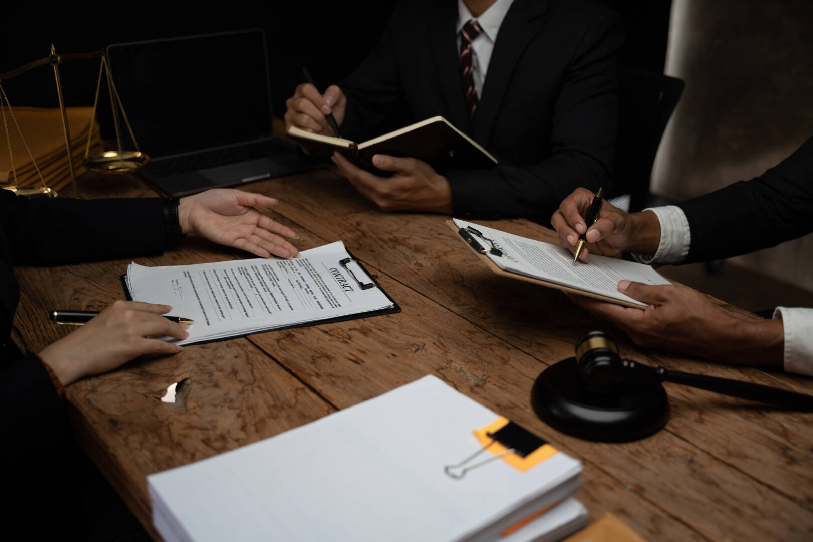 Close up lawyer businessman working or reading lawbook in office workplace for consultant lawyer concept.Lawyer working at table in office, focus on scales of justice